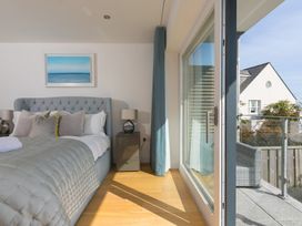 A bedroom with a bed and balcony at 2 Remera St Ives