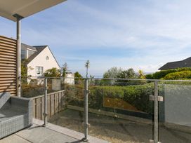 A balcony with a glass railing and a couch at 2 Remera in St Ives