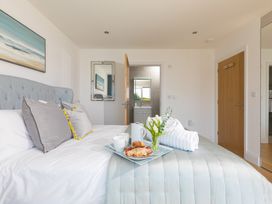 A bedroom with a bed and tray of food and drink at 2 Remera in St Ives