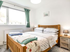 A bedroom with a bed and window at Orchard View in St. Austell