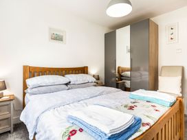 A bedroom with two beds and a wardrobe at Orchard View in St. Austell