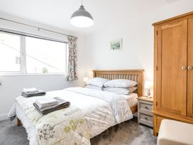 A bedroom with a bed and wardrobe at Orchard View in St. Austell