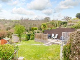A garden with decking and lounge chairs at Orchard View in St. Austell