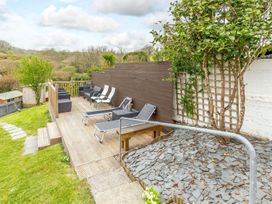 A garden with decking and lounge chairs at Orchard View in St. Austell