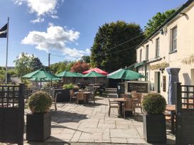 Outdoor seating area with tables and umbrellas at Polgooth Inn in St. Austell