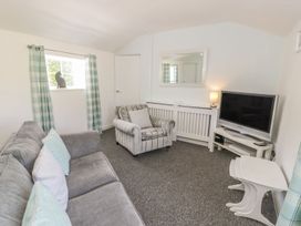 A living room with a sofa and television at Falconers Cottage