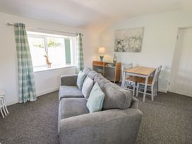 A living room with a sofa and dining table at Falconers Cottage