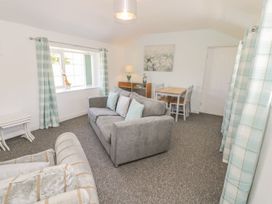 A living room with a sofa, table and chairs at Falconers Cottage