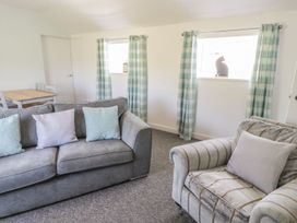 A living room with a sofa and dining table at Falconers Cottage