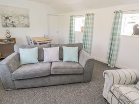 A living room with a sofa and table at Falconers Cottage