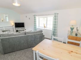 A living room with a sofa and television at Falconers Cottage