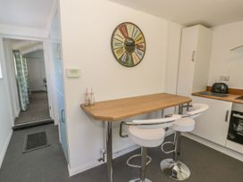 A kitchen with bar stools and a counter at Falconers Cottage