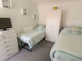 A bedroom with two beds and a television at Falconers Cottage
