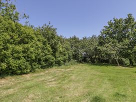 A garden area with grass and trees at Falconers Cottage