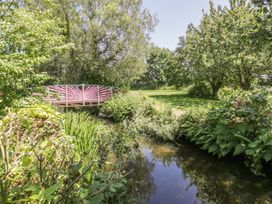 A garden with a stream and a bridge at Falconers Cottage
