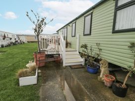 An outdoor view of a mobile home with steps and garden features at Beachside in Towyn