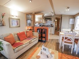 A living room with a sofa and table at Beachside in Towyn