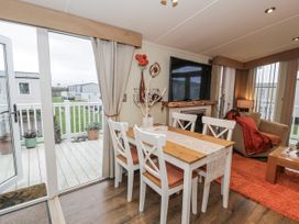 A dining room with a table and chairs at Beachside in Towyn