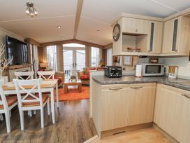 A kitchen with dining area and couch at Beachside in Towyn