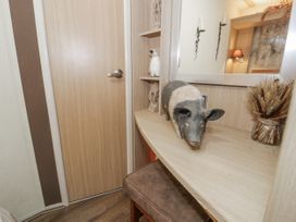 A shelf with decorative items and a door at Beachside in Towyn