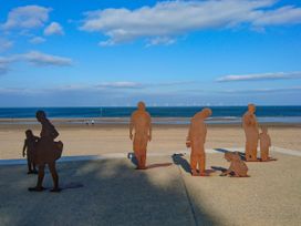 A beach with sculptures of people at Beachside in Towyn