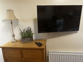 A living room with a television and lamp on a chest of drawers at The Rocks in Newry