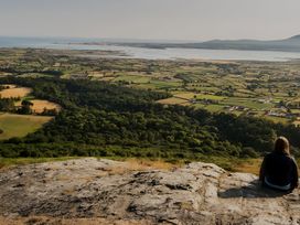 A view of fields and a river with a person sitting on a hill at The Rocks in Newry