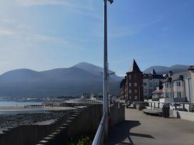 A view of a seaside pathway with buildings and mountains at The Rocks in Newry