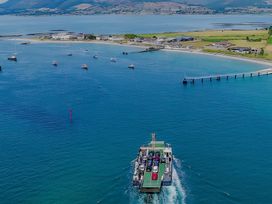 A ferry moving towards a pier with boats in the water at The Rocks in Newry