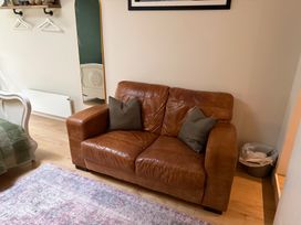 A living room with a sofa and mirror at Studio Apartment at High Dyke Farm Cockermouth