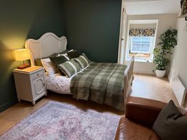 A bedroom with a bed and nightstand at Studio Apartment at High Dyke Farm in Cockermouth