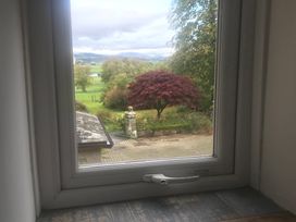 A view from a window showing a tree and garden at Studio Apartment at High Dyke Farm Cockermouth