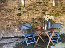 An outdoor seating area with a table and chairs at Studio Apartment at High Dyke Farm in Cockermouth