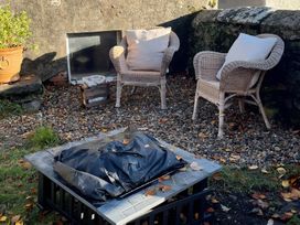 A garden with wicker chairs and a fire pit at Studio Apartment at High Dyke Farm, Cockermouth