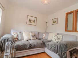 A living room with a sofa and paintings at Greenham Rise in Norton-Sub-Hamdon