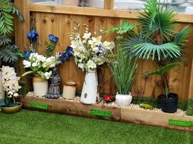 A garden arrangement with flowers, ornamental plants and a statue at Greenham Rise in Norton-Sub-Hamdon