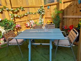 A garden setting with a table and chairs at Greenham Rise in Norton-Sub-Hamdon