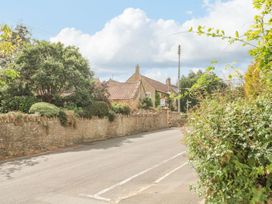 A house with a wall and trees on a street at Greenham Rise Norton-Sub-Hamdon