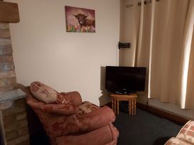 A living room with an armchair and television at 87 Ballyveaghmore Road in Newry