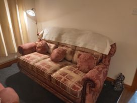 A sofa with cushions and a lamp in a living room at 87 Ballyveaghmore Road Newry