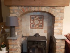 A fireplace with a stove and lamp in the living room at 87 Ballyveaghmore Road Newry