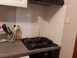 A kitchen with a gas stove and cooking utensils at 87 Ballyveaghmore Road Newry