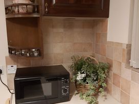 A kitchen with a microwave and a plant in a basket at 87 Ballyveaghmore Road Newry