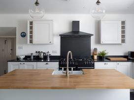 A kitchen with cabinets and a stove at The Cottage in Helston