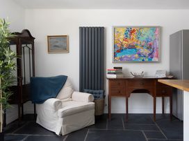 A living room with a chair and painting at The Cottage in Helston
