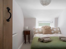 A bedroom with a bed and side table at The Cottage in Helston