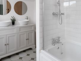 A bathroom with dual sinks and a bathtub at The Cottage in Helston