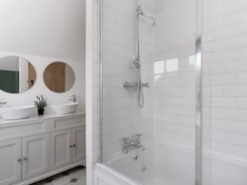 A bathroom with a shower and two hand basins at The Cottage in Helston