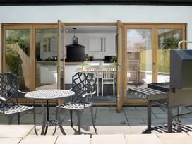 An outdoor patio with a dining table and chairs at The Cottage in Helston