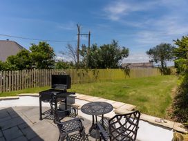 A garden with a grill and seating area at The Cottage in Helston